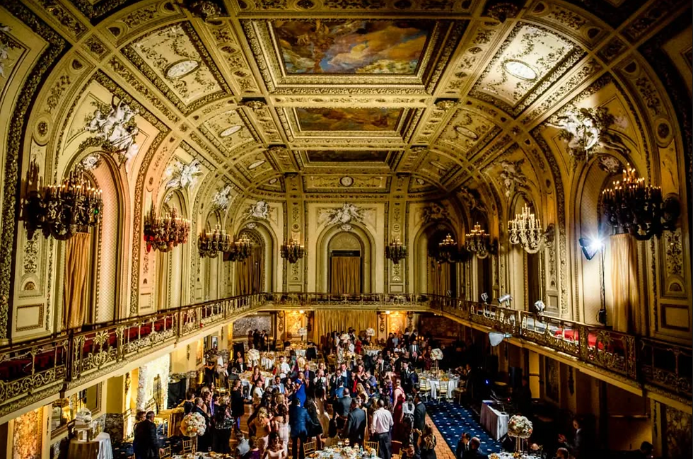 A big party happening in the Gold Ballroom at The Congress Plaza Hotel with a crowd of people mingling on the dance floor.