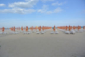 Strand mit Sonneliegen und Sonnenschirmen