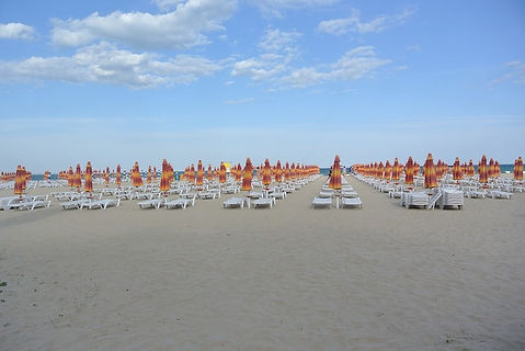 Strand mit Sonneliegen und Sonnenschirmen