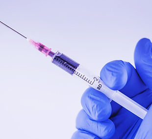 Syringe in gloved hand