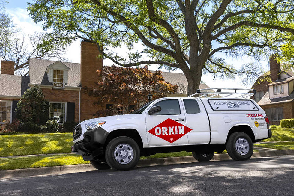 A white Toyota Tacoma from Orkin Pest Control parked in front of a residential home.