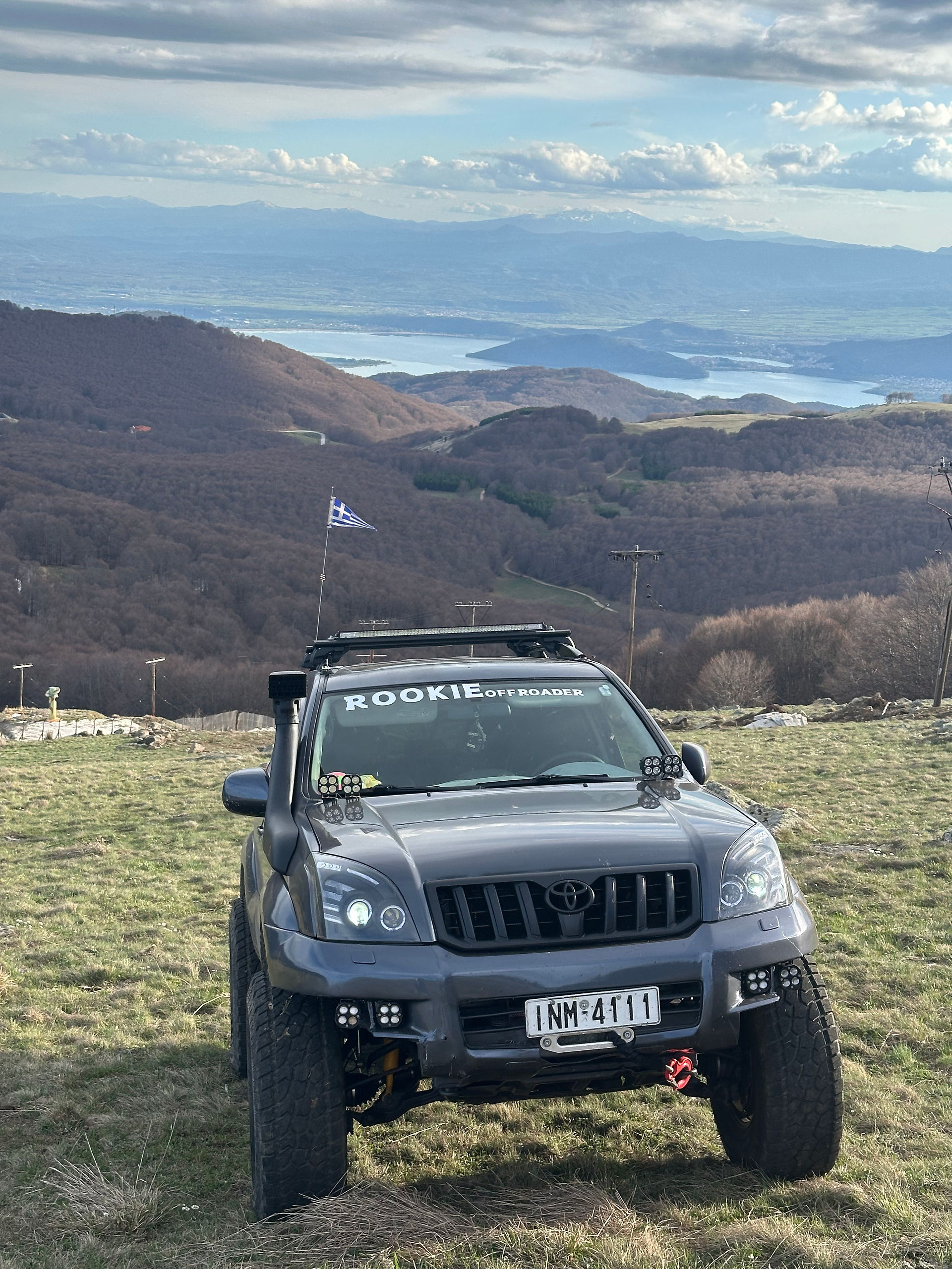 A Gray offroad SUV in front of a brown mountain range