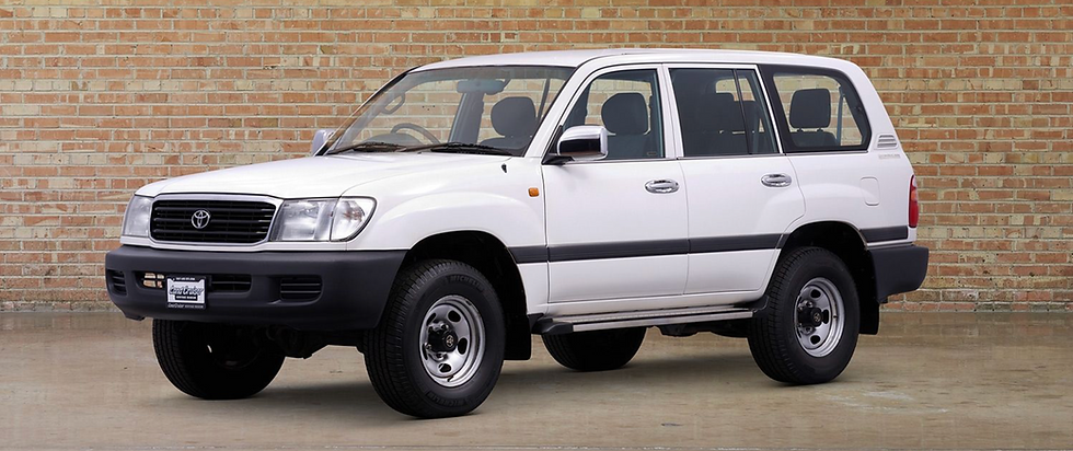 White Toyota SUV in front of a brick wall