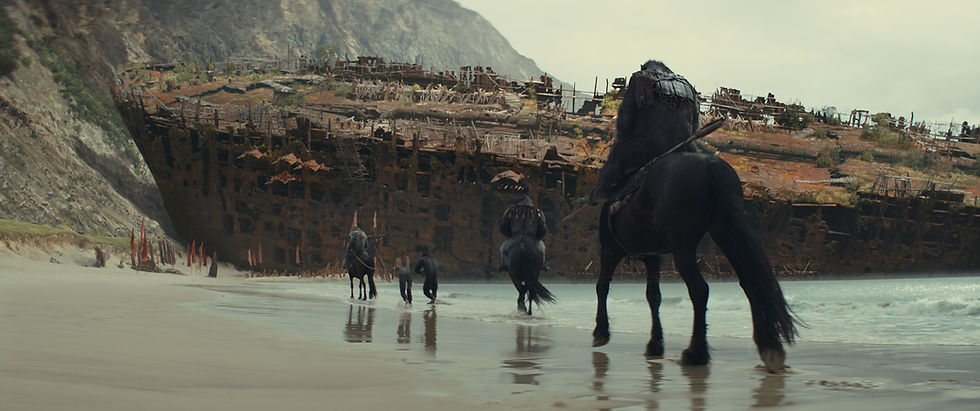 Des singes sur des chevaux sur une plage et devant une épave de bateau dans le film La Planète des Singes : Le Nouveau Royaume