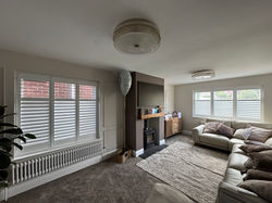 Full-height hardwood shutters across a Droitwich living room