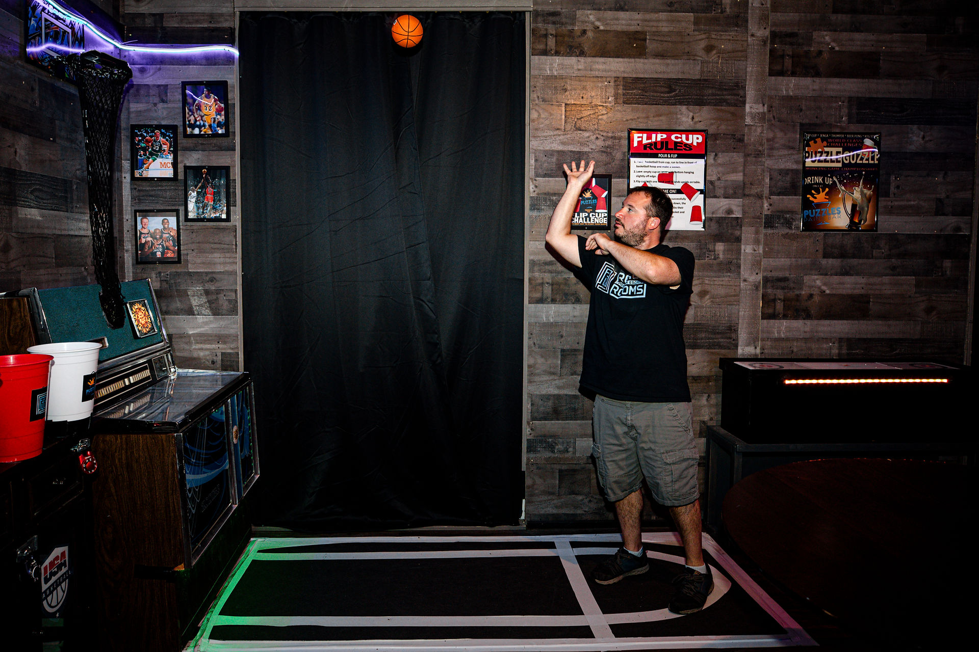 Man throwing a ball at a hoop in the set of The Hungover Games