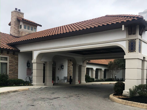 Spanish style retirement home entrance with carport.
