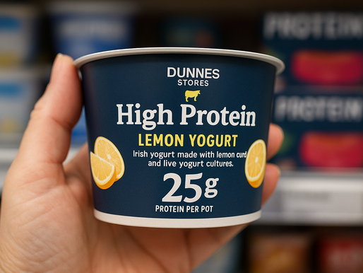 A hand holding a supermarket-branded lemon yoghurt boldly labelled “High Protein” — a visual example of how marketing has saturated the shelves.