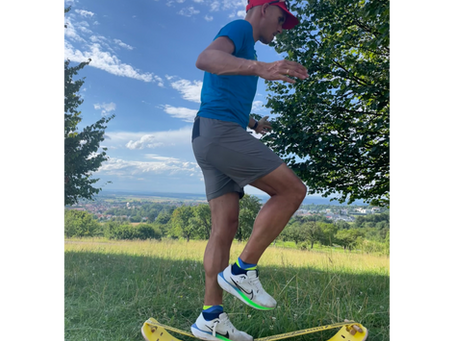 Sportler auf einer Slackline und Board beim Balancetraining