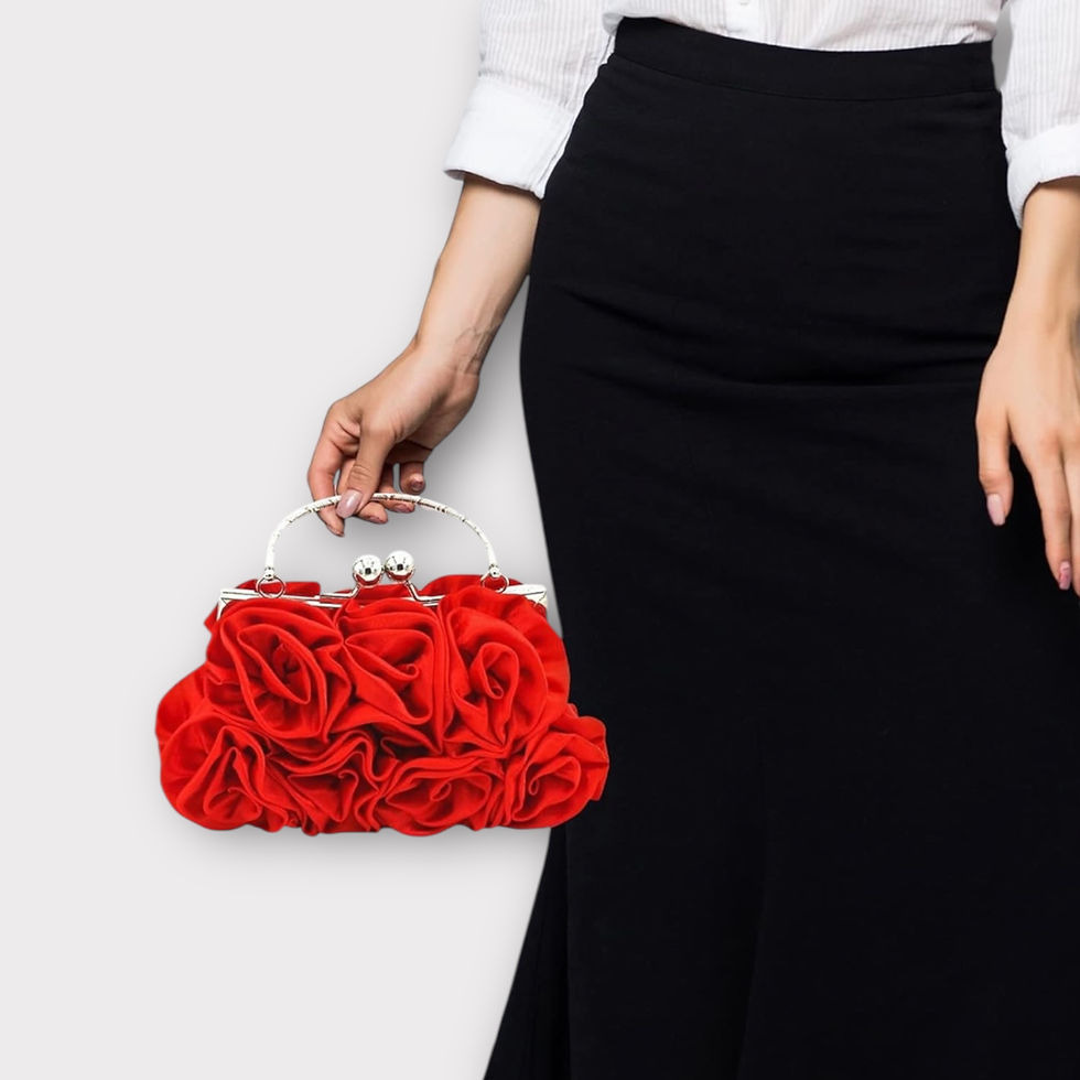 Woman holding a red rose-covered clutch handbag with silver clasp, elegant floral evening bag, styled with a white blouse and high-waisted black skirt.