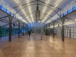 A scaffolding tower being used to install loudspeakers in a venue