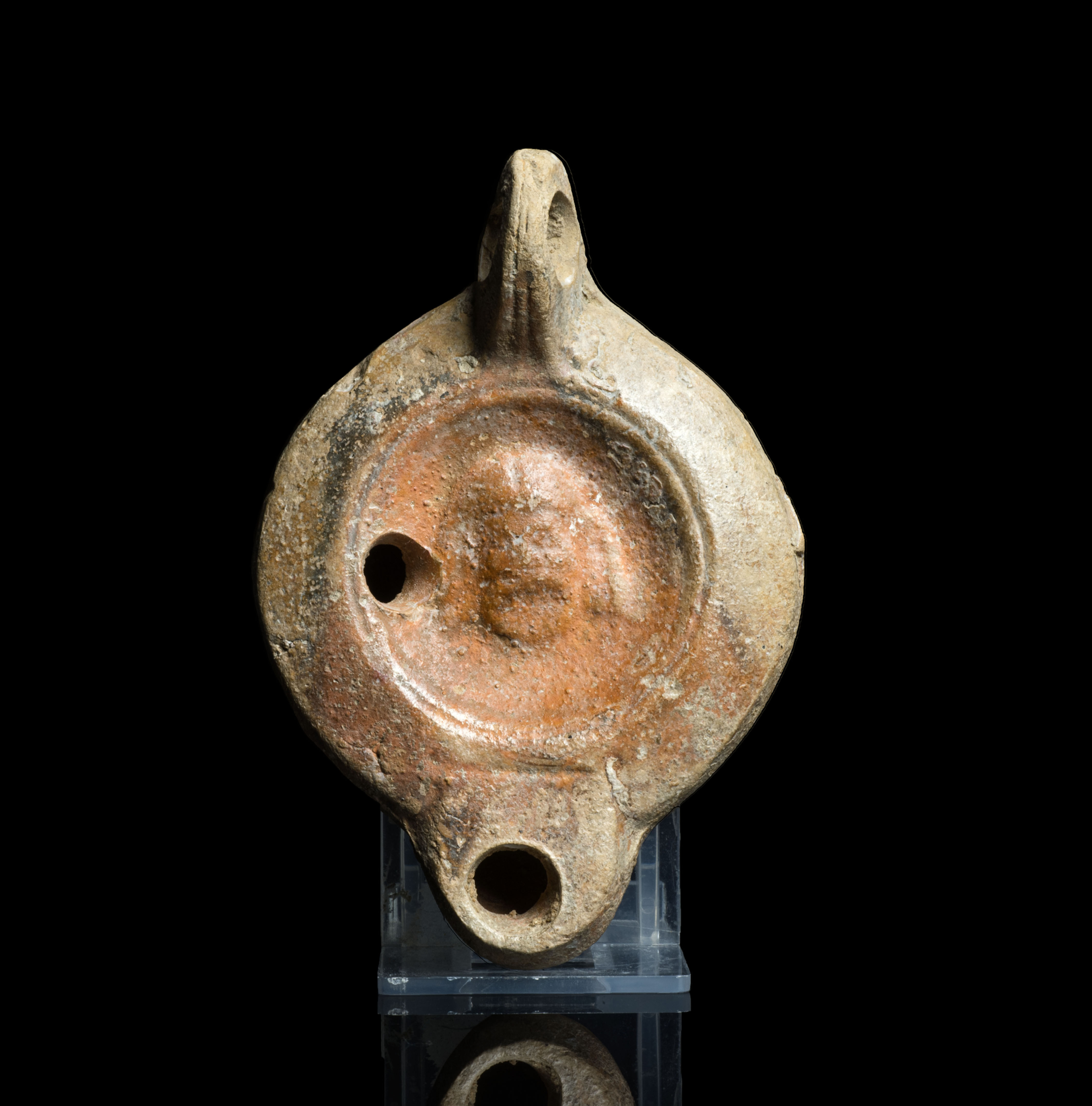 Ancient Roman oil lamp with slave mask