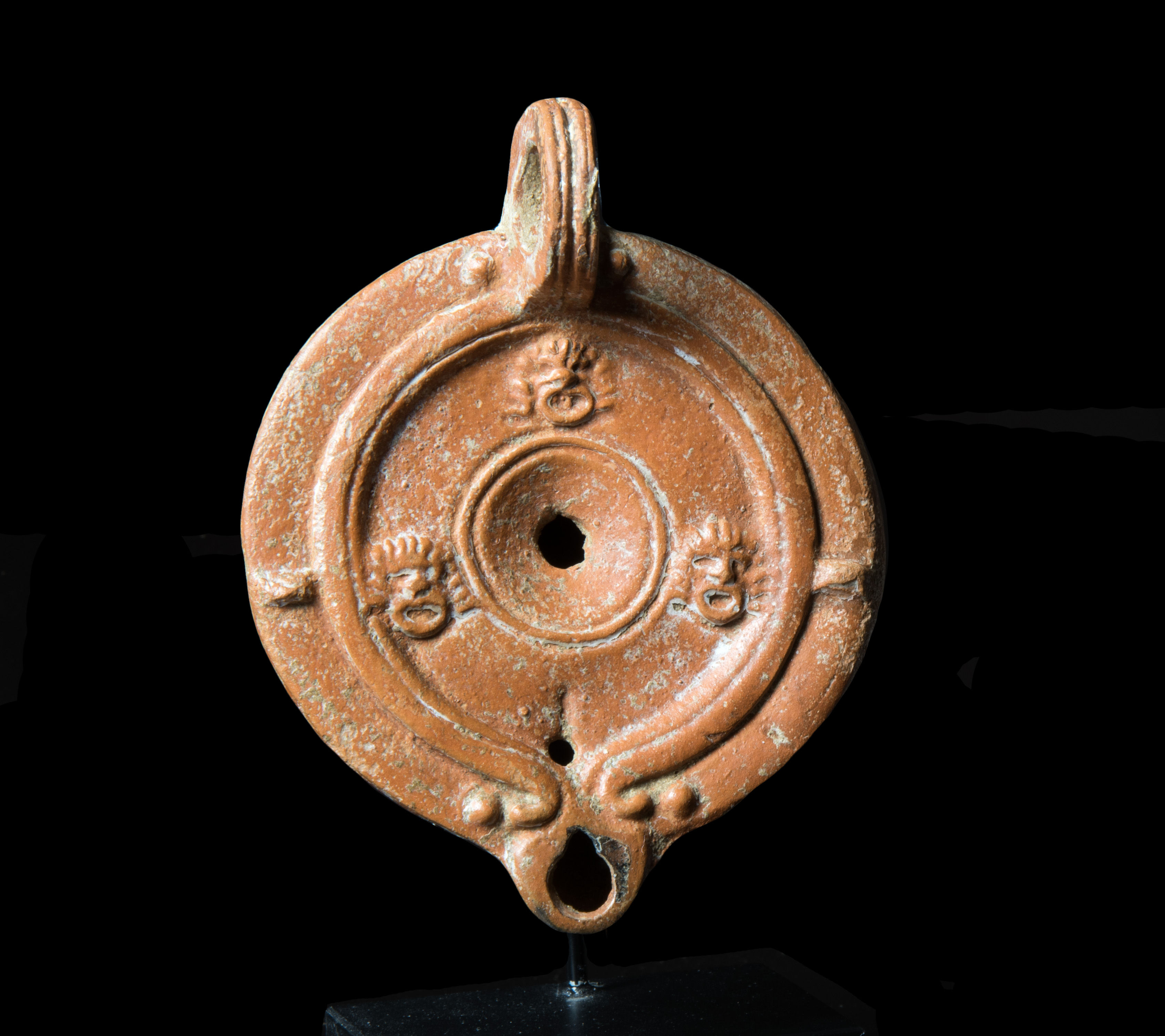 Roman oil lamp decorated with theatre masks
