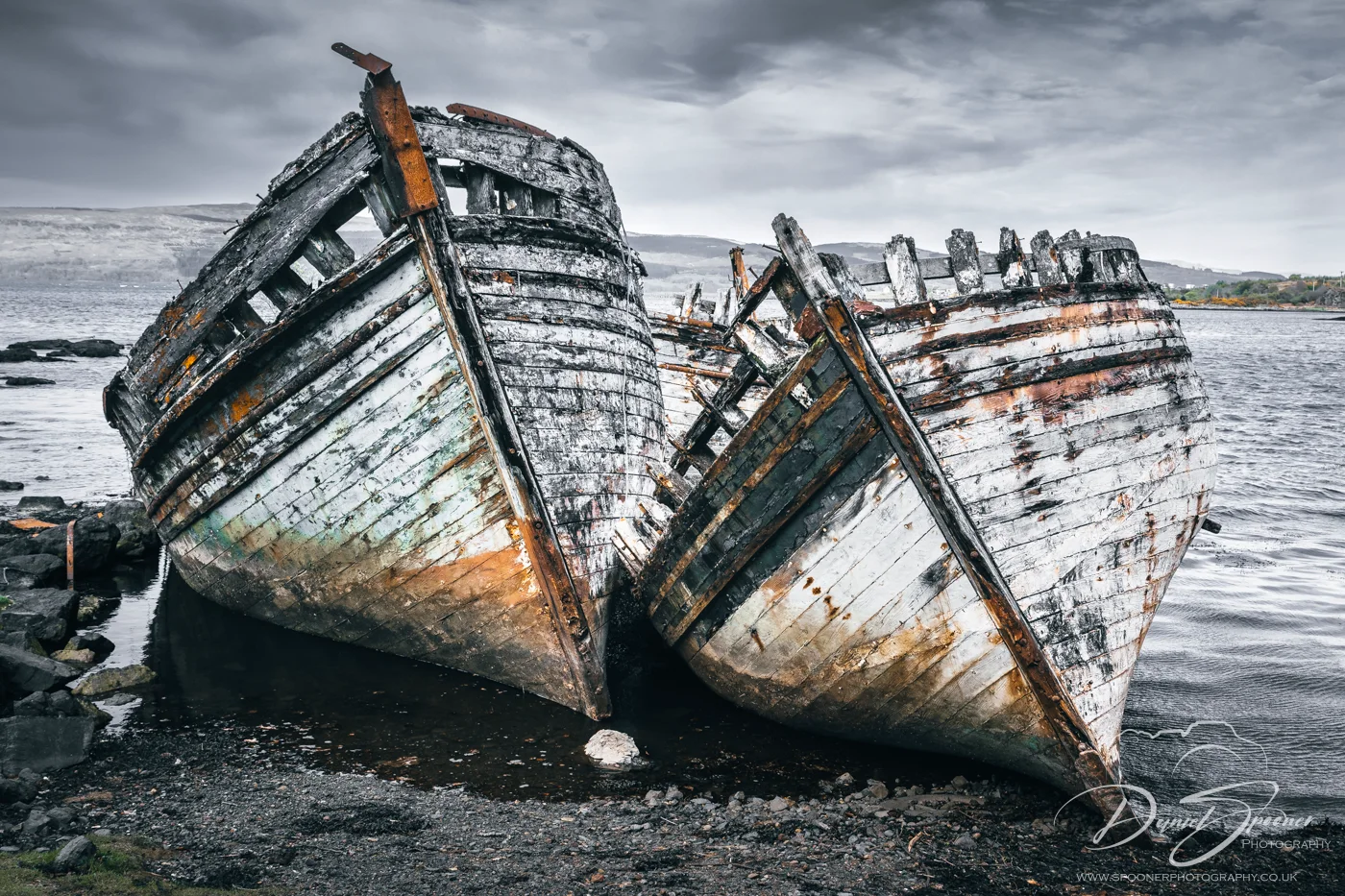 Two wooden shipwrecks in Salen resting beside each other in still waters front view
