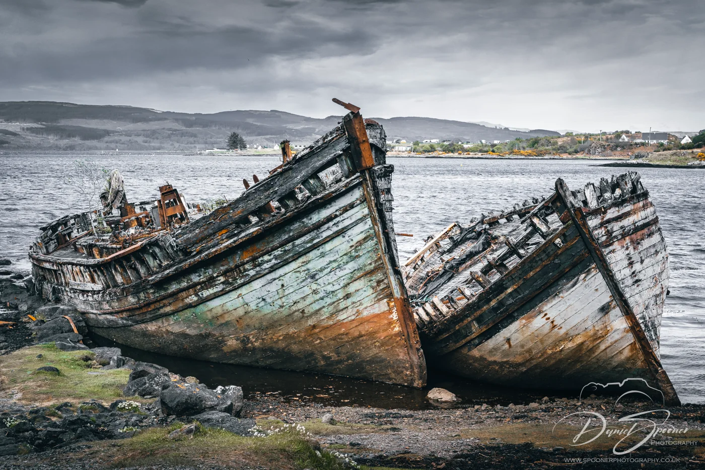 Two wooden shipwrecks in Salen resting beside each other in still waters front view