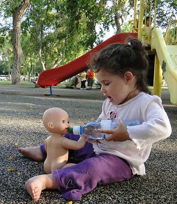 toddelr feeding her doll