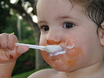 a baby eating by himself