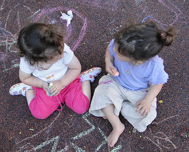 2 girls sitting and playing together