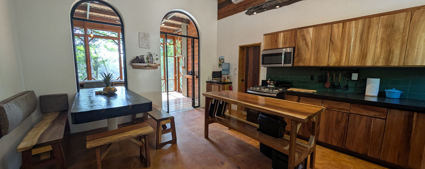 Tall arched glass doors overlooking the river and Belizean jungle at Villa Ora