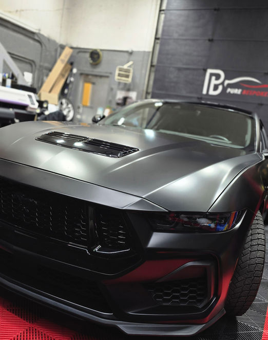 Ford Mustang wrapped in Satin Black vinyl with paint correction, clay bar treatment, and ceramic coating for satin wraps by Pure Bespoke in Montreal.
