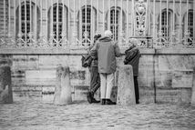 Three people standing talking by a decorative fence, architectural details. Jeff Bana Photography