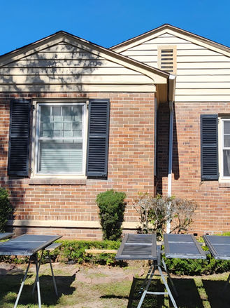 Exterior home improvement project featuring freshly restored and repainted shutters, enhancing the curb appeal and refreshing the home's brick facade.