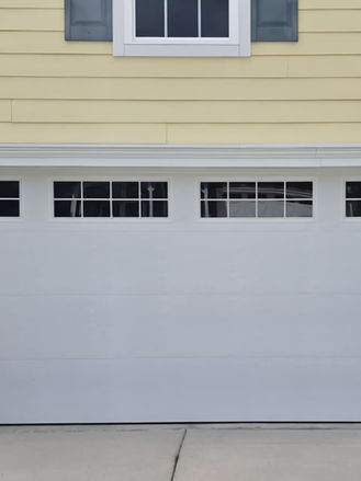 Repair and restored garage door trim with new exterior molding, providing a clean and finished appearance.