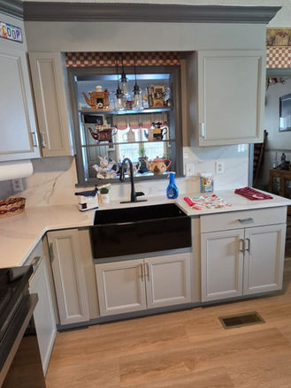 Completed kitchen remodel featuring a black farmhouse sink, quartz countertops, gray cabinets, and new ceiling fan.