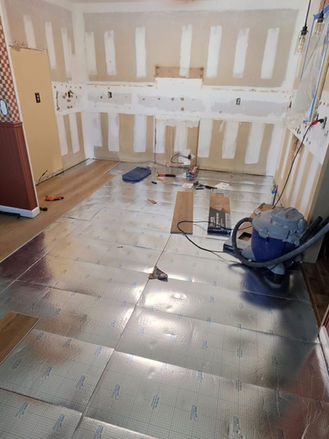kitchen demolition and floor installation in progress during renovation.