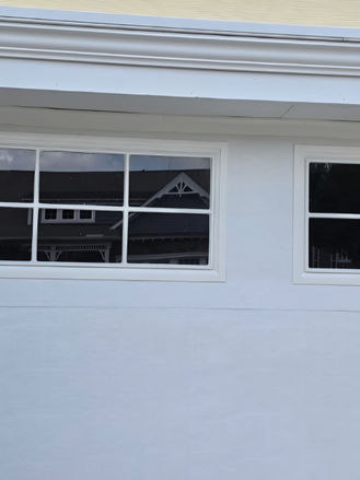 Upper garage door trim before repair, showing worn exterior molding and trim above the garage door opening.