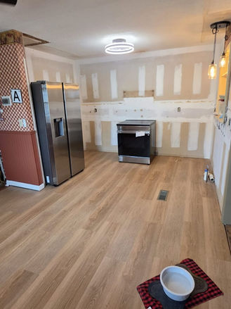 New flooring installed and kitchen prepared for cabinet installation.