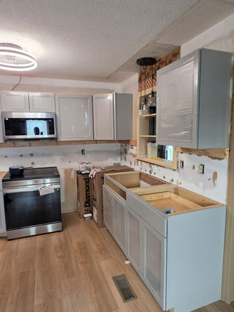 New gray shaker cabinets being installed during kitchen remodel.