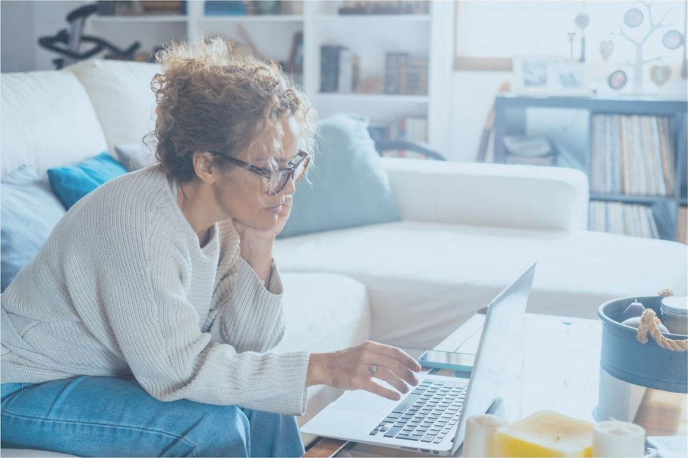 Woman sitting in her living room looking at laptop