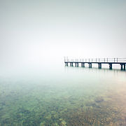 Pier or jetty silhouette in a foggy lake. Garda lake, Italy, Europe