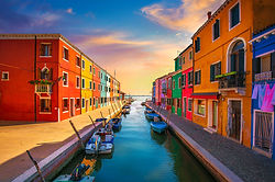Burano island canal, colorful houses and boats in late afternoon, Italy Europe