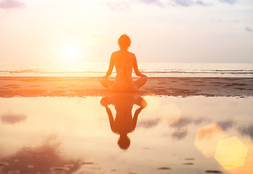 woman meditating by the beach.