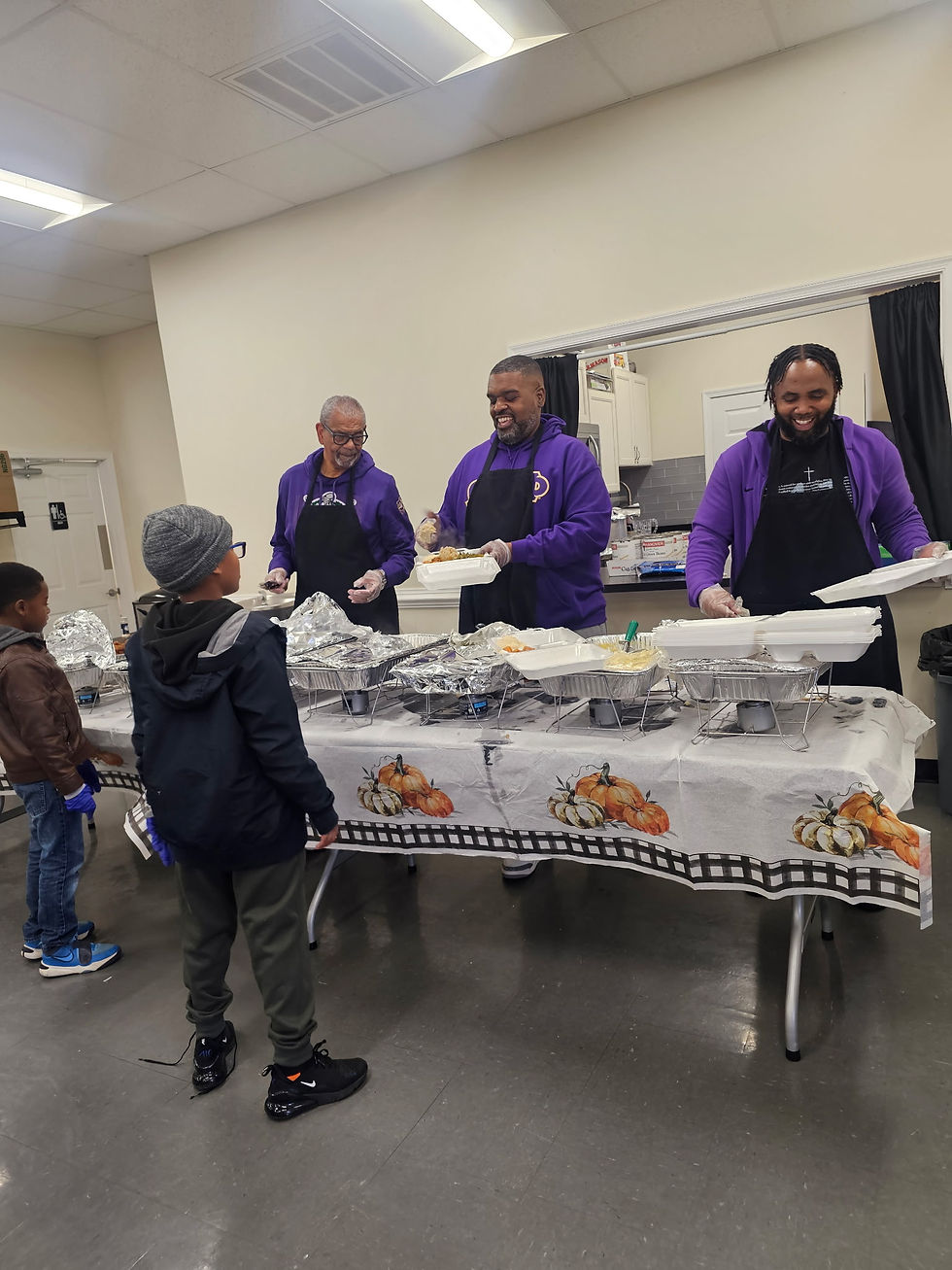 Eye-level view of volunteers preparing food trays in a community kitchen
