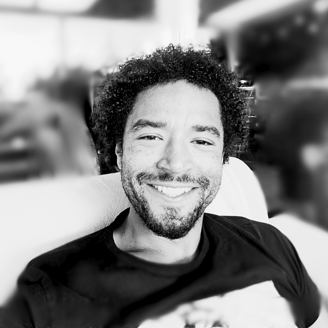 Kai Gabriel smiling in headshot displayed in black and white values