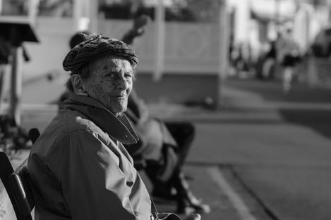 Portrait d’une femme âgée sur un banc face à la mer à Saint-Jean-de-Luz, regard vers l’horizon.