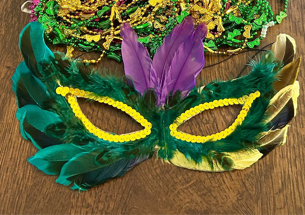 a mardi gras mask made of green and purple feathers with gold sequins around the eye holes
