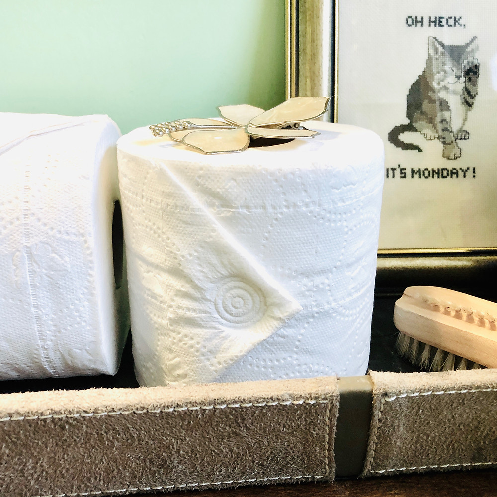 Toilet paper is folded and sealed decoratively using the sink faucet.