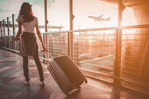 1_young-woman-pulling-suitcase-airport-terminal-copy-space.jpg