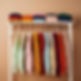 Colorful sweaters folded and hanging on rack