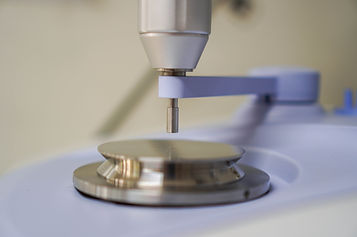 Testing surface of an FTIR spectrometer, with the anvil above the ATR crystal. The sample gets compressed between these surfaces for analysis.