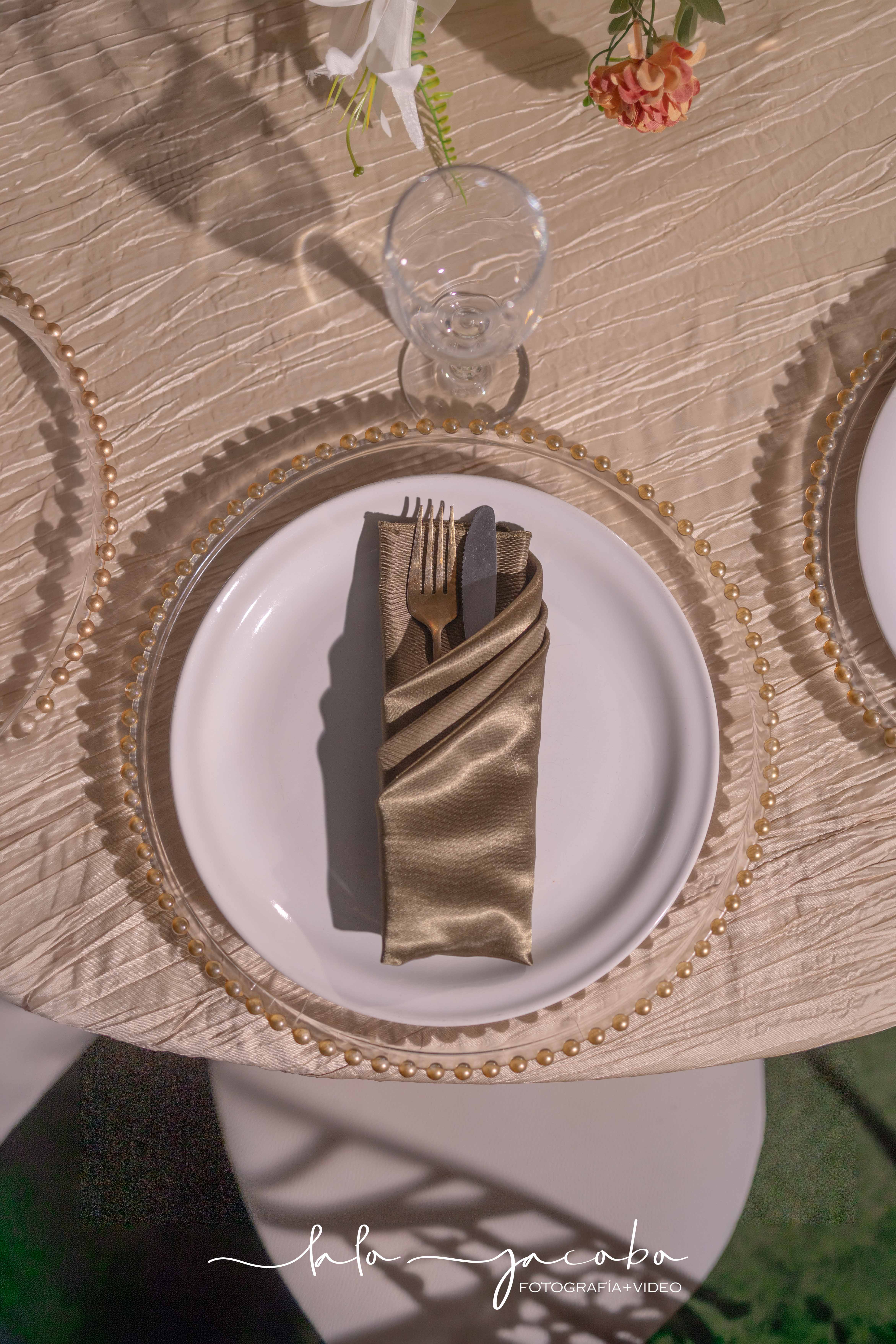 Montaje de mesa para una boda nocturna con detalles dorados y flores
