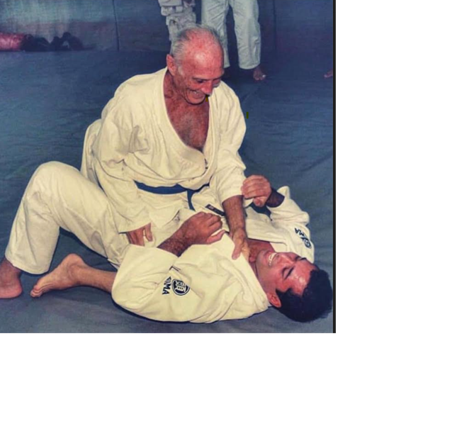 An older Helio Gracie perfroming a technique