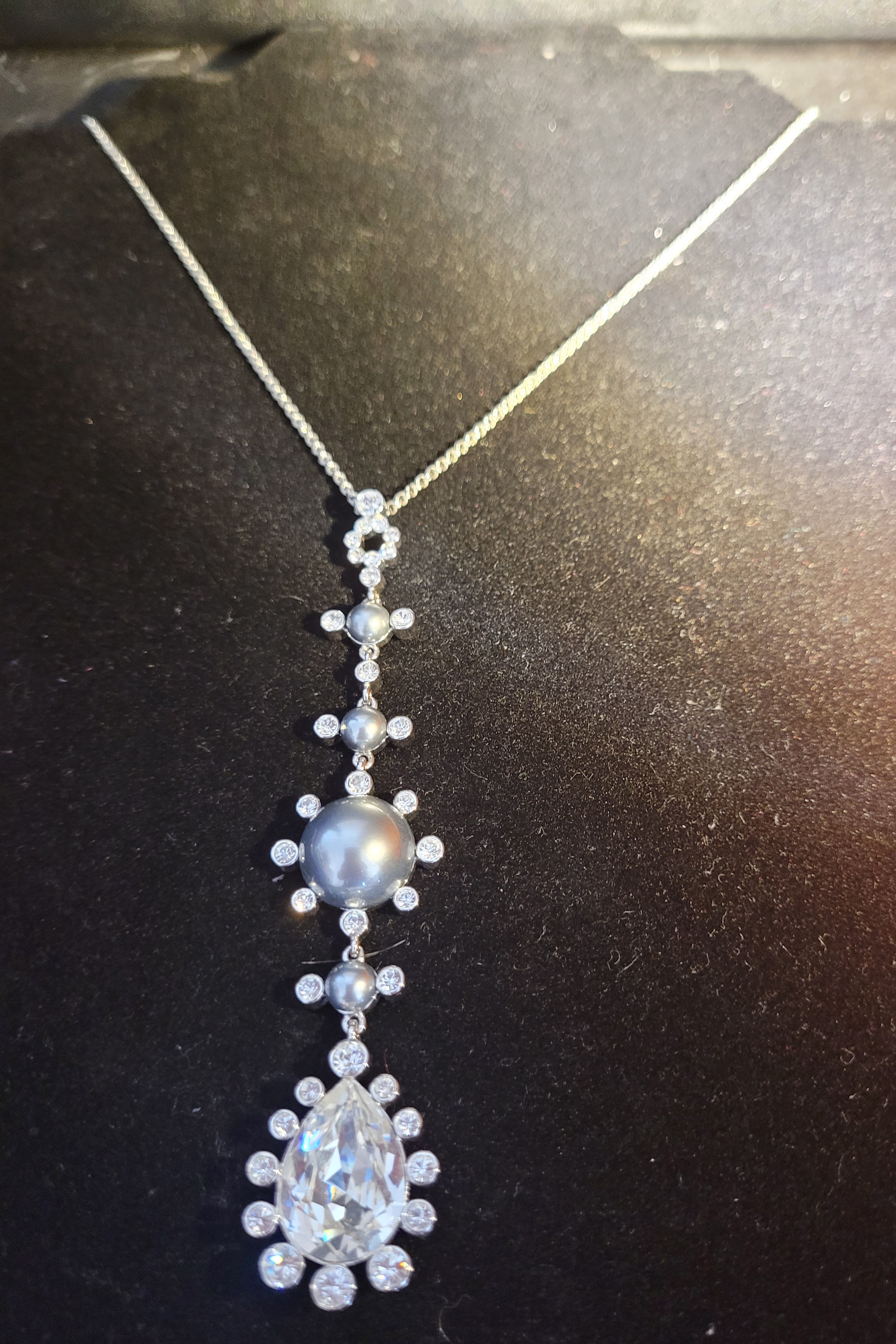 - Joan Rivers  - Silver tone metal with faux pearl & crystal.