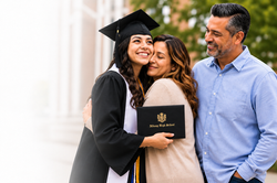 mom and girl hugging with dad watching