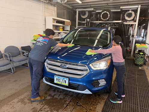 Main Street Shine Wash Staff carefully hand‑dry the exterior of a vehicle with towels for a streak‑free, polished shine.