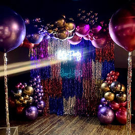 shimmering foil tassel backdrop with neon sign ' lets party'